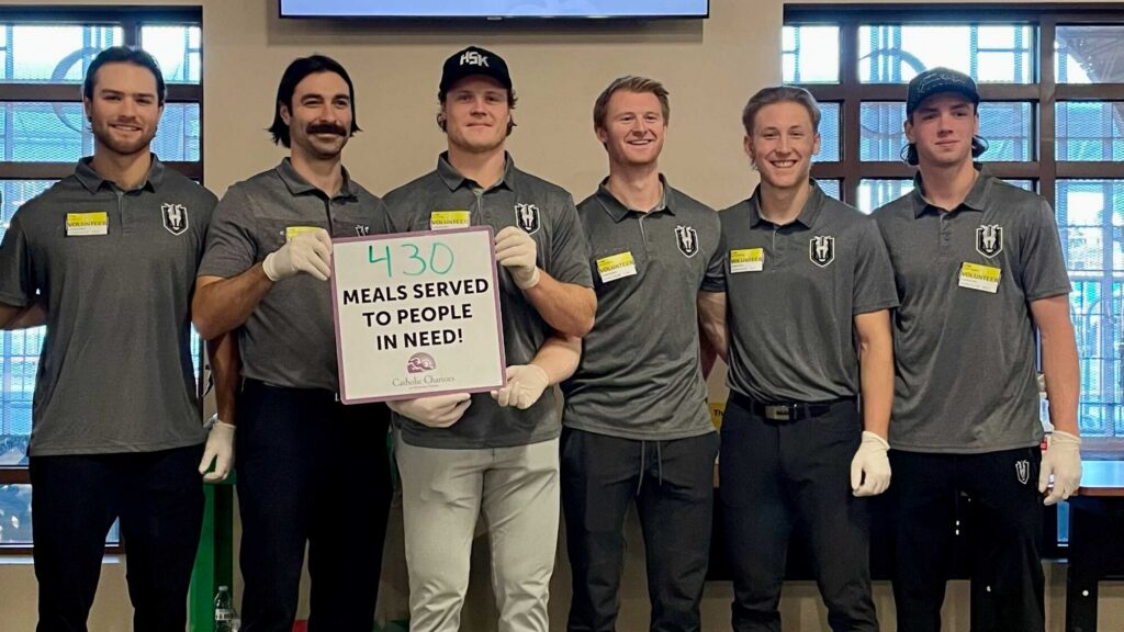 Silver Knights players holding sign with 430 meals served to people in need